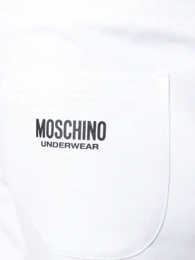 Shop Moschino Logo Stripe Track Pants In White