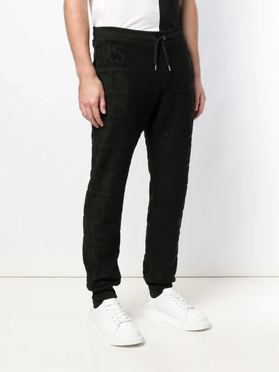 Shop Versace Textural Logo Track Pants In Black