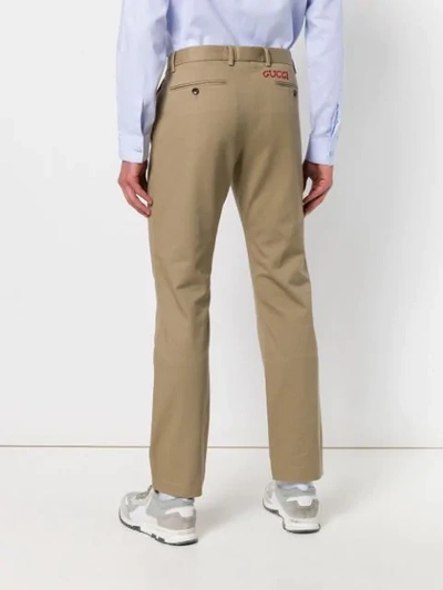 Shop Gucci Embroidered Logo Chinos In Neutrals
