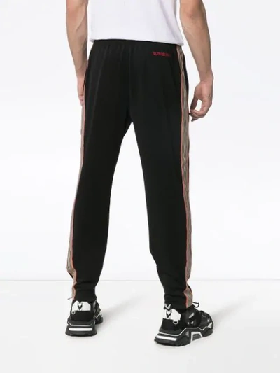 Shop Burberry Icon Stripe Jersey Trackpants In Black