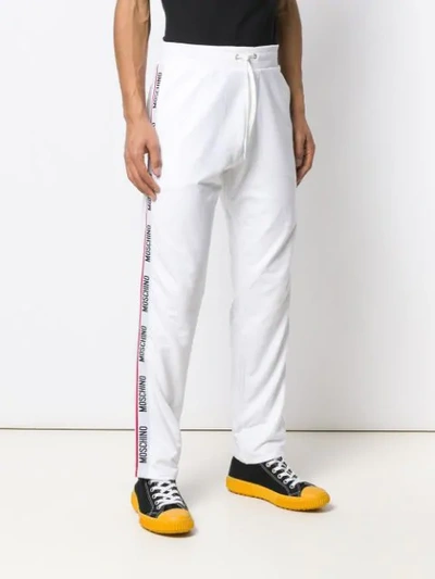 Shop Moschino Logo Track Pants In White