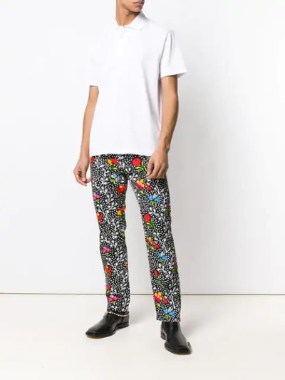 Shop Versace Floral Print Trousers In Black