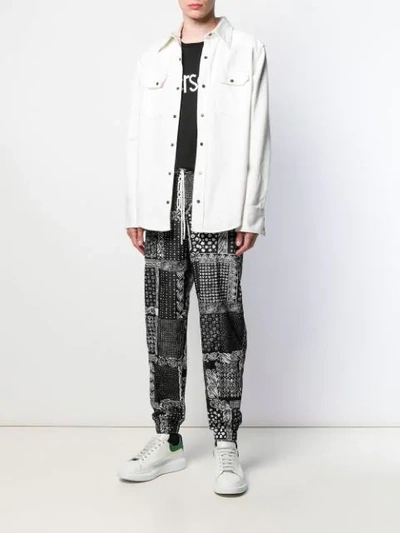 Shop Versace Bandana Print Trousers In Black