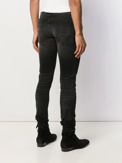 Shop Amiri Distressed Skinny Jeans - Black