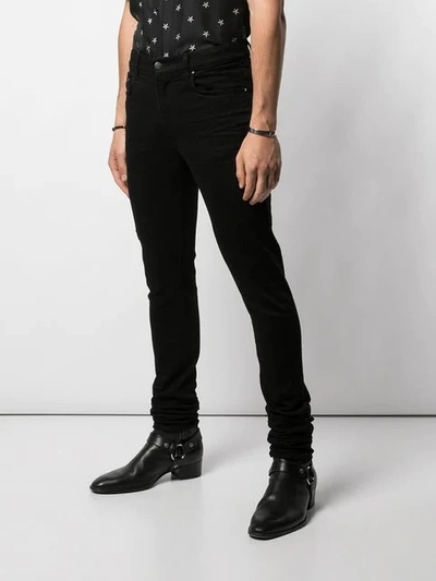 Shop Amiri Skinny Jeans - Black