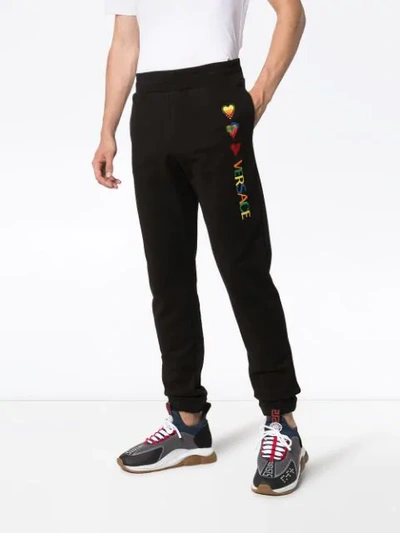 Shop Versace Heart-embroidered Track Trousers In Black