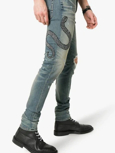 Shop Amiri Snake Embroidered Distressed Jeans In Indwh