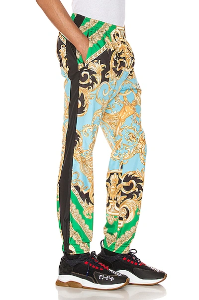 Shop Versace Print Pants In Green & Blue