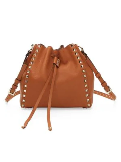 Shop Valentino Garavani Small Rockstud Leather Bucket Bag In Tan