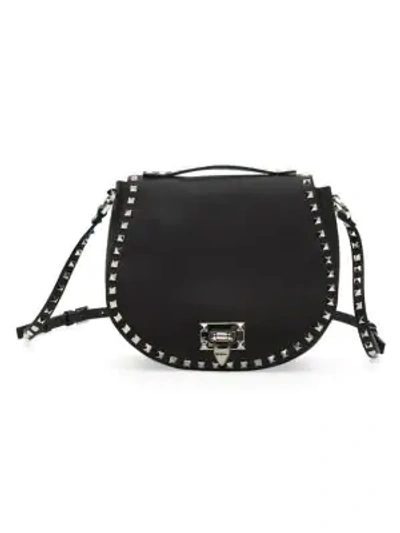 Shop Valentino Garavani Small Rockstud Leather Saddle Bag In Black