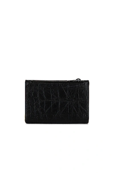 Shop Saint Laurent Bi-fold Zipped Monogram Wallet In Black
