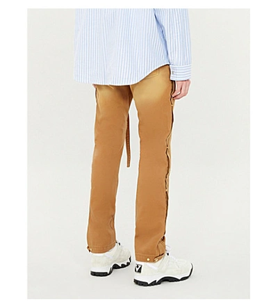 Shop Fear Of God Button-embellished Regular-fit Tapered Denim Trousers In Rust