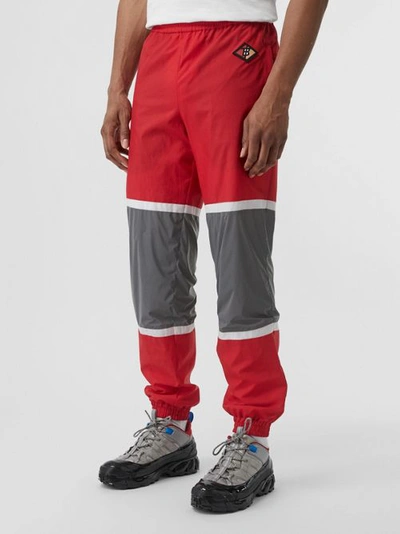 Shop Burberry Logo Graphic Striped Nylon Trackpants In Bright Red