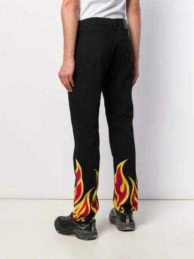 Shop Msgm Flame Print Trousers In Black