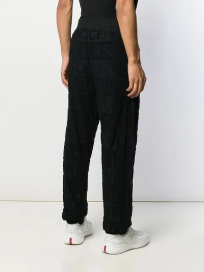 Shop Versace All Over Logo Track Trousers In Black