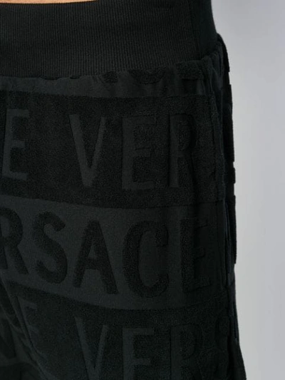 Shop Versace All Over Logo Track Trousers In Black