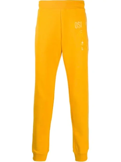 Shop Moschino Tonal Logo Print Track Pants In Yellow