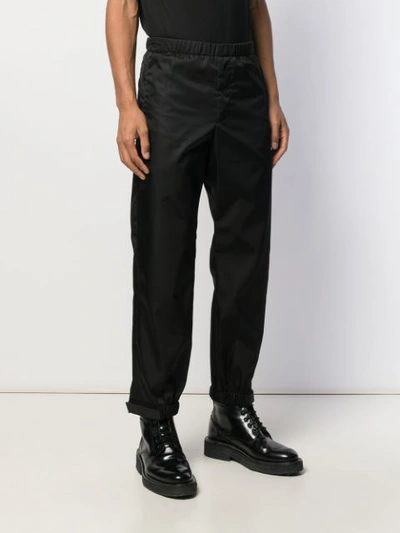 Shop Prada Elasticated Waist Strap Trousers In Black