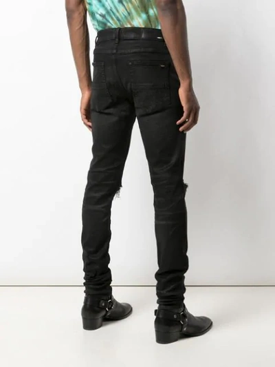 Shop Amiri Trasher Distressed Jeans In Black