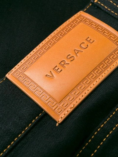 Shop Versace Flared Safety-pin Jeans In Black