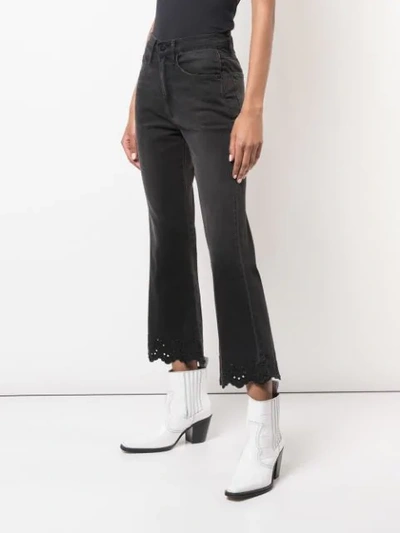 Shop Frame Scalloped Hem Flared Jeans In Black