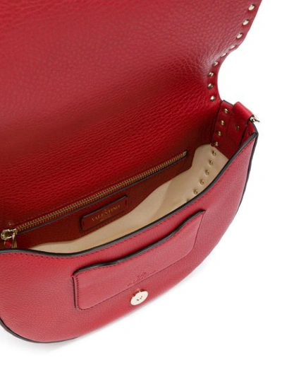 Shop Valentino Garavani Rockstud Saddle Shoulder Bag - Red