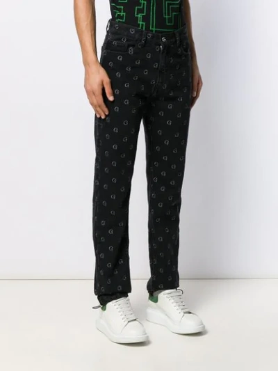 Shop Geo Monogram Print Trousers In Black