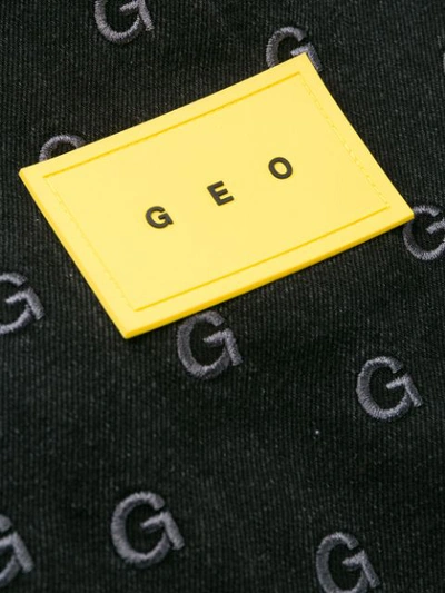 Shop Geo Monogram Print Trousers In Black