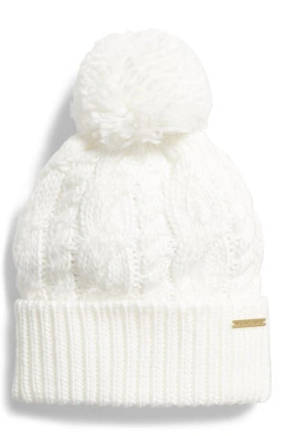 Shop Michael Michael Kors Pompom Cable Knit Beanie In Cream/ Hp Gold