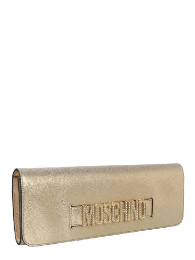 Shop Moschino Logo Embellished Detail Clutch Bag In Gold