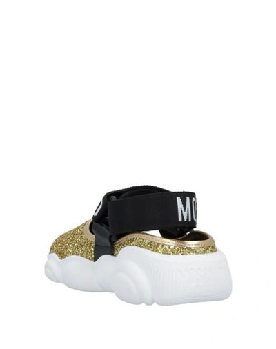 Shop Moschino Sneakers In Gold