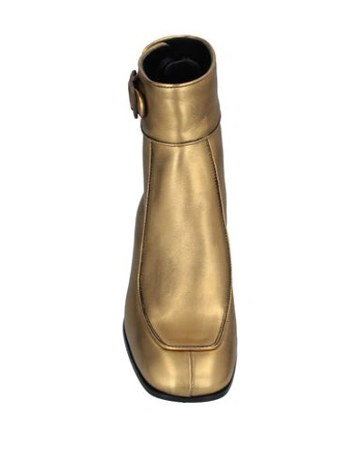 Shop Saint Laurent Ankle Boots In Gold