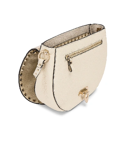 Shop Valentino Small Rockstud Saddle Bag In Light Ivory