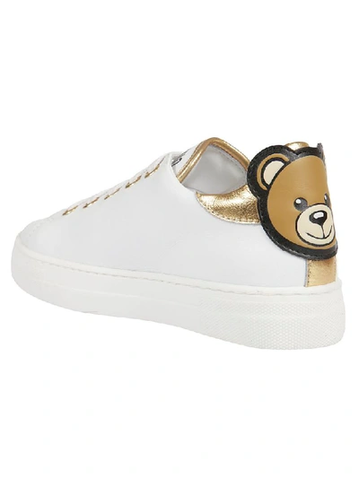 Shop Moschino Logo Print Sneakers In White/gold