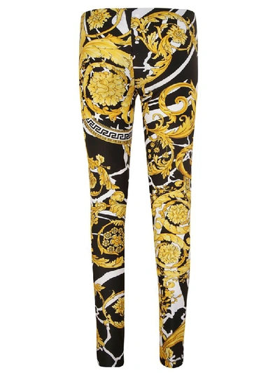 Shop Versace All-over Print Trousers In Black/gold