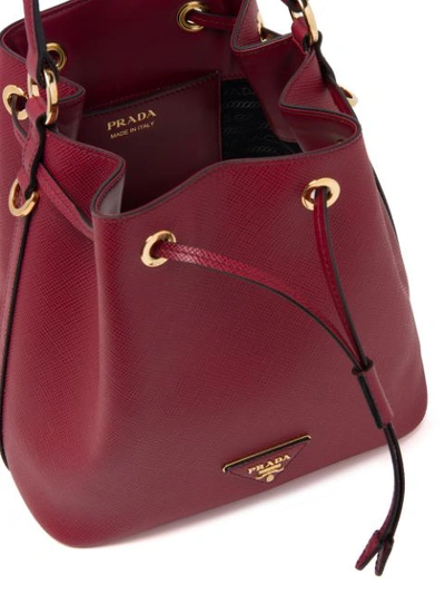 Shop Prada Saffiano Bucket Bag In Red