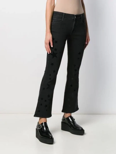 Shop Stella Mccartney Star Print Kick-flare Jeans In Black