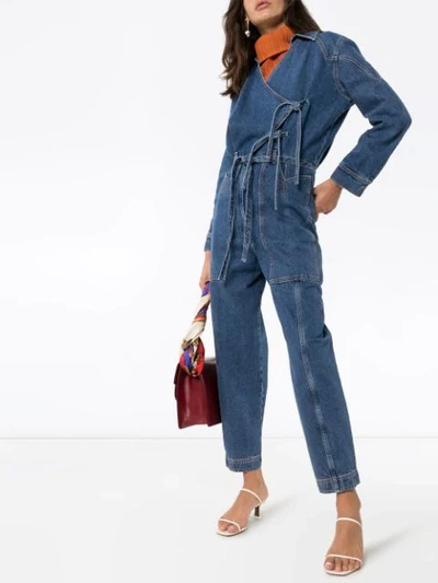 Shop Nanushka Naki Wrap Denim Jumpsuit In Blue