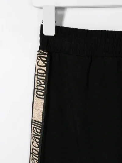 Shop Roberto Cavalli Junior Logo Print Trousers In Black