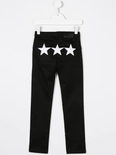 Shop Givenchy Star Print Trousers In Black