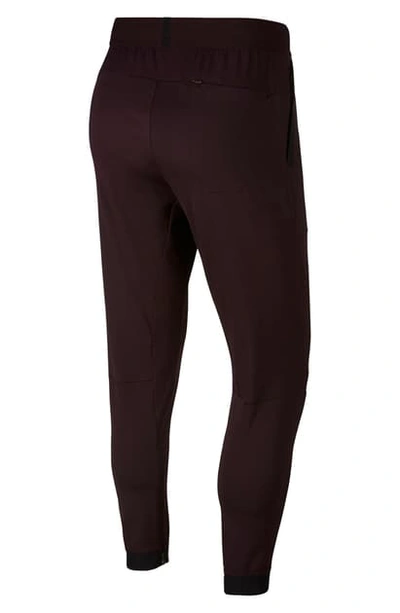 Shop Nike Flex Track Pants In Burgundy Ash/ Black