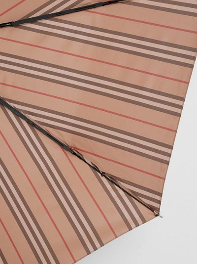 Shop Burberry Icon Stripe Folding Umbrella In Camel