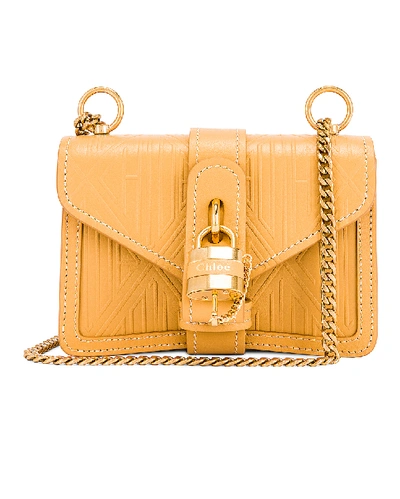 Shop Chloé Mini Aby Chain Embossed Monogram Shoulder Bag In Honey Gold