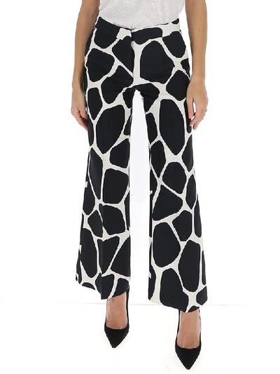 Shop Valentino Flared Giraffe Print Trousers In Multi