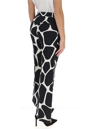 Shop Valentino Flared Giraffe Print Trousers In Multi