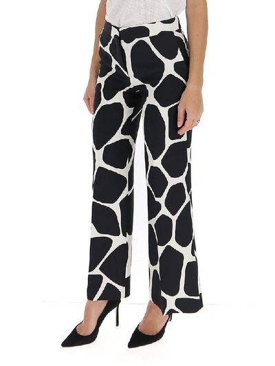 Shop Valentino Flared Giraffe Print Trousers In Multi