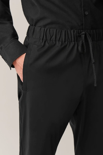 Shop Cos Relaxed-fit Cuffed Trousers In Black