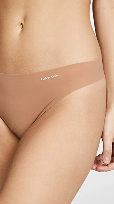 Shop Calvin Klein Underwear Invisibles Thong In Bronzed