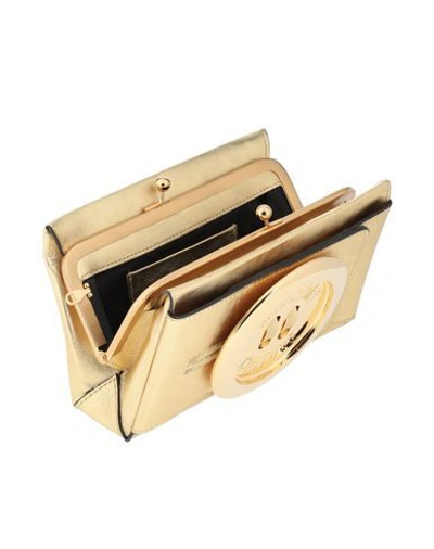 Shop Moschino Handbag In Gold