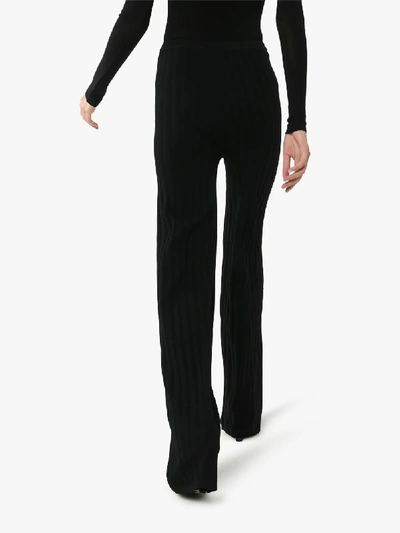 Shop Totême Cour Ribbed Knit Trousers In Black